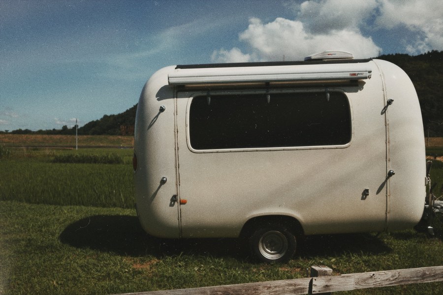 Vintage travel trailer parked in a grassy field