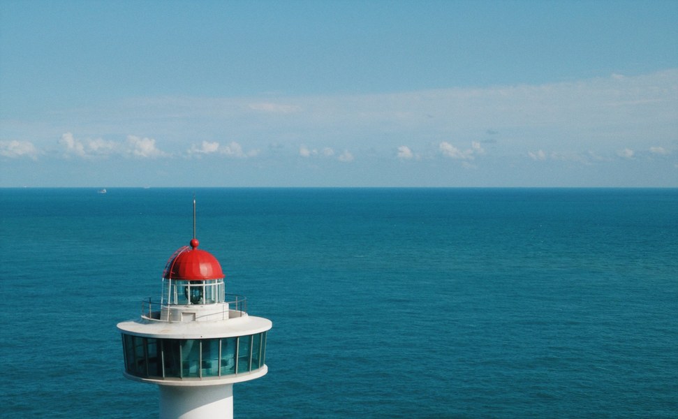 Red-domed lighthouse against open sea