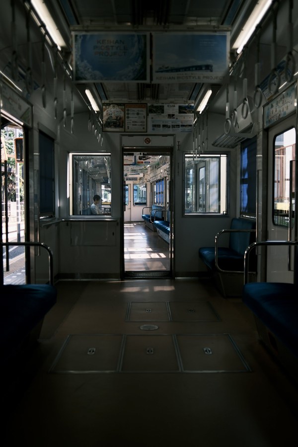 Empty train car interior, doors open to a platform
