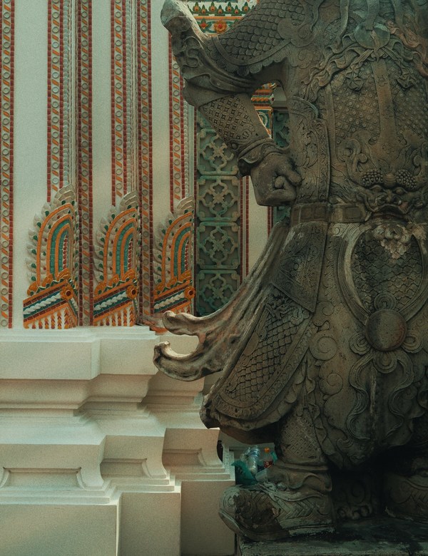 Carved stone guardian figure detail at a Thai temple
