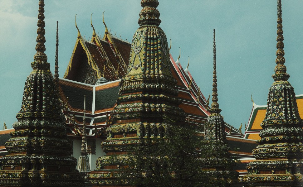 Ornate gilded temple spires against a clear sky, Bangkok